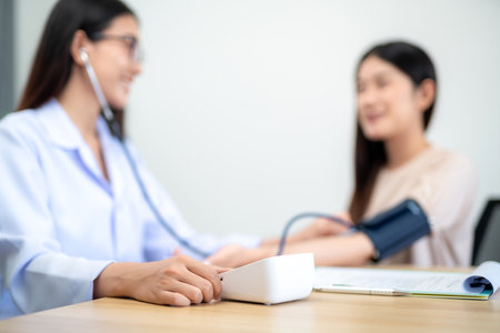 A female doctor using digital sphygmomanometer and stethoscope to check patient's heartbeat at hospital. selective focus of digital pressure gauge.の写真素材