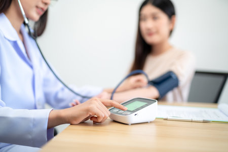 Close up hand of Female doctor using digital sphygmomanometer and stethoscope to check patient's heartbeat at hospital. Medical and health concept.の写真素材
