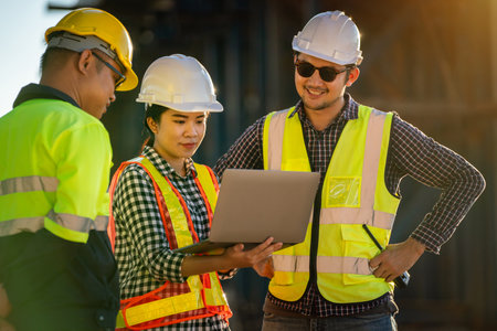 A Professional team of architects, engineers, foremen working on laptops at expressway construction site. Teamwork concept of road construction.の写真素材