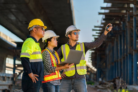 A Professional team of engineers, architects, inspecting and working outside on expressway construction site with laptop at road construction site. engineering and architecture concept.の写真素材