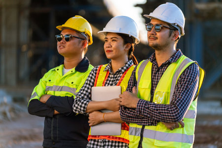 A team of architects, civil engineers, engineers, diversity standing with crossed arms confidently at the expressway construction project. selective focus of female engineer.の写真素材