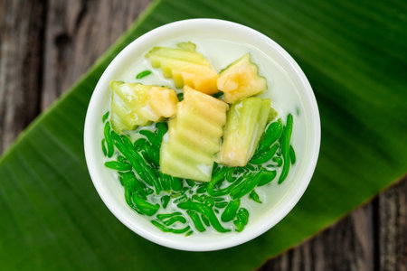 Top view of Lod Chong is a dessert made from rice flour. green from pandan leaves and fresh coconut milk laid on a wooden background.の写真素材