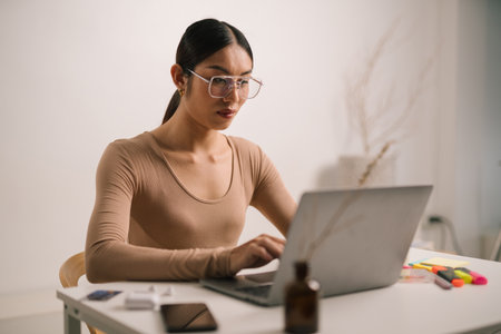 Asian person using laptop computer, sitting in living room in apartment. attractive man is working from home, Online shopping, watching videos or writing emails. LGBTの写真素材