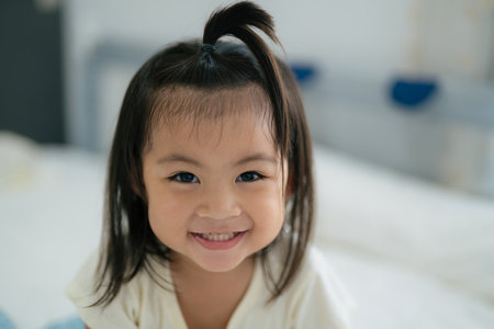 Asian child cute girl smiling while looking at the camera at home.の写真素材