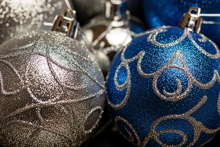 Close-up of shiny blue and silver glitter baubles used as Christmas tree decorations, showcasing festive holiday texture and seasonal elegance for design projectsの素材