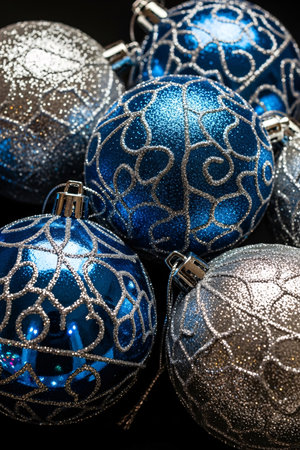 Close-up view of silver glitter and shiny blue Christmas baubles with festive lighting reflections, perfect for holiday decoration and seasonal celebration themesの素材