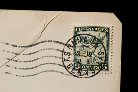 Close up of a vintage Cupid stamp and the textured aged paper of an envelope representing old-fashioned love and emotional declaration.の素材