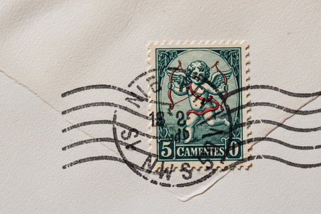 Macro detail of an old-fashioned envelope corner with a Cupid stamp highlighting the texture and vintage feel of the aged stationery.の素材