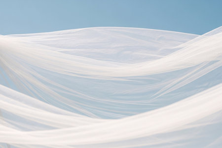 Abstract motion white veil fabric against a sunny blue sky symbolizing the ethereal beauty and freedom of the wedding day.の素材