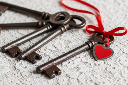 Key to my heart antique keys on vintage lace with a red ribbon and heart tag symbolizing the unlocking of romantic love.の素材