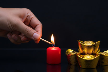 Intimate still life candle flame and ingots reflection emphasizes the sharp focus on the traditional elements.の素材