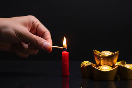 Warm candle glow highlights gold on a dark background creating a dramatic look for a high impact visual.の素材