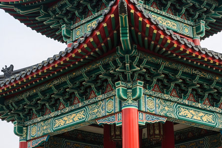 Traditional Chinese pavilion eaves and pillars a vibrant architectural element with gold and red colors representing oriental decorating.の素材