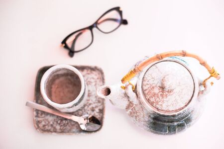 a cup of tea , a teapot and glasses on the tableaの写真素材