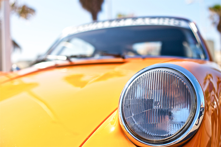 An old yellow polished car  on the streetの写真素材