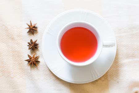 a beautiful white cup of tea with anise flower in the morning on on fluffy  fair blanketの写真素材