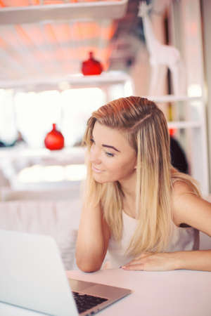 a young businesswoman is working  on a laptop in a cafe