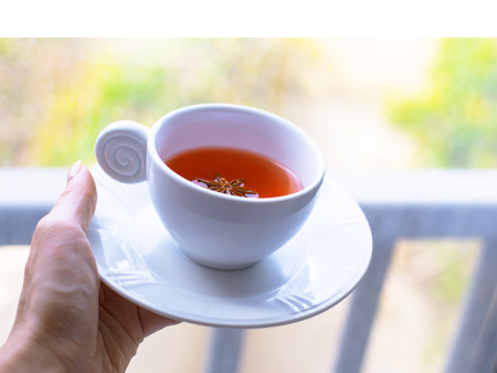 A girl is bringing a cup of tea in the morning,a hand with a cup of teaの写真素材