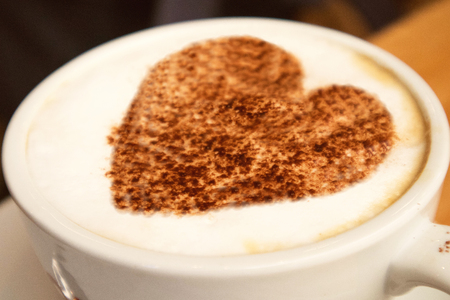closeup of a big white cup of  hot coffee cappuccino with art design heart on it  standing on a wooden background,love conceptの写真素材
