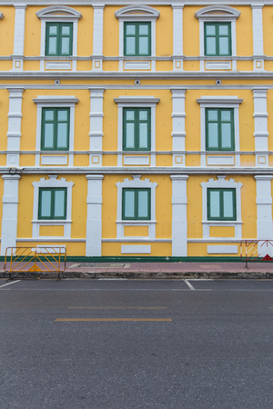 Yellow apartment with green wooden windowsの写真素材