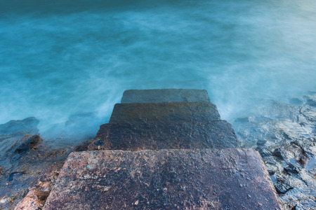 Stone steps leading towards the ocean in foreground
