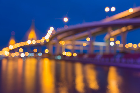 Abstract blurred bokeh light of cross intersection highway and bridge with water reflectionの写真素材