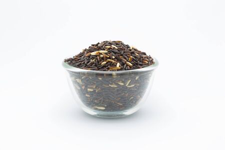 Coarse organic black rice on white backgroundの写真素材