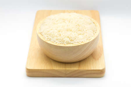 White rice in bowl on wooden board, white backgroundの写真素材