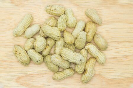 Root peanuts on wooden board, white background