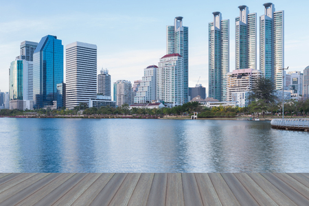 Opening wooden floor, Water pool at Public Park with office building before sunset with water reflectionの写真素材