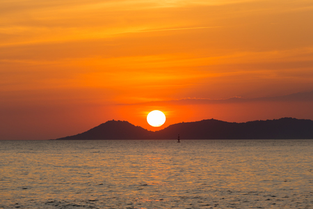 Sunset behind mountain and sea, dramatic view.の写真素材