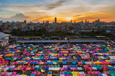 Sunset sky over weekend night market, multiple colour backgroundの写真素材