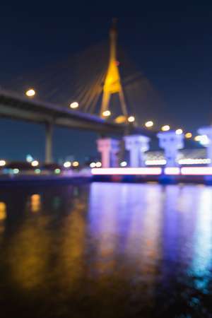 Abstract blurred bokeh lights suspension bridge and watergate night viewの写真素材