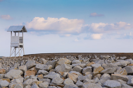 Lifeguard tower over the rocky walkway with blue sky backgroundの写真素材