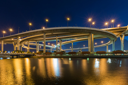 Twilight over Highway interchanged river front with reflection at nightの写真素材