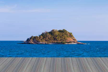 Opening wooden floor, Small lonely island over seacoast skyline, natural landscape backgroundの写真素材