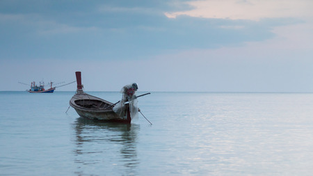 Small fishing boat on the sea during twilight sky backgroundの写真素材