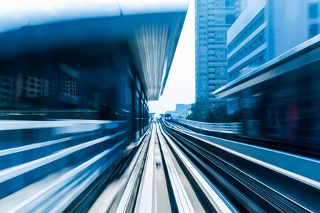 Abstract blurred motion train moving into city business downtown background