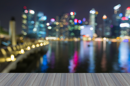 Opening wooden floor, Singapore city blurred light nihgt view sea front, abstract backgroundの写真素材