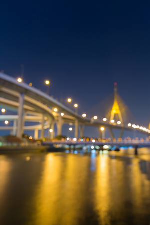 Twilight blurred bokeh light suspension bridge with reflection, abstract backgroundの写真素材