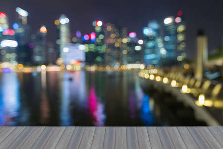 Opening wooden floor, Blurred bokeh city of Singapore city night light, abstract backgroundの写真素材