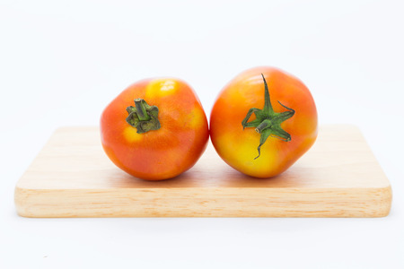 Fresh tomato on wooden board, on white background