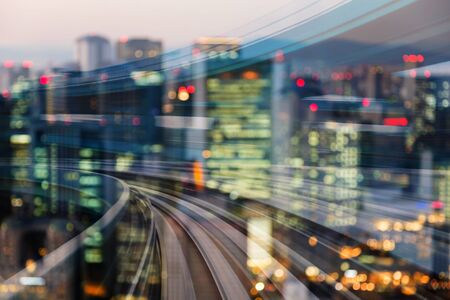 Motion blurred train curved with blurred bokeh city light, double exposureの写真素材