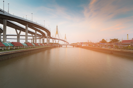 Bangkok River with twin suspension bridge and highway background, Thailandの写真素材