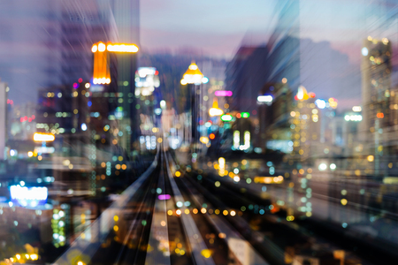 Blurred bokeh light city downtown night double exposure moving train track, abstract backgroundの写真素材