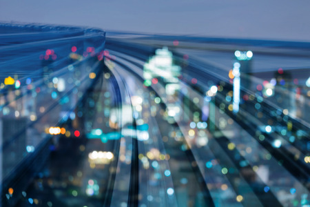 Blurred bokeh night city business downtown light with motion train track, abstract backgroundの写真素材