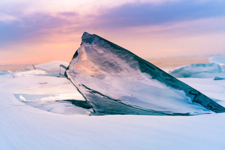 Ice breaking on frozen lake with after sunset background, Baikal Russia winter season natural landscape の写真素材