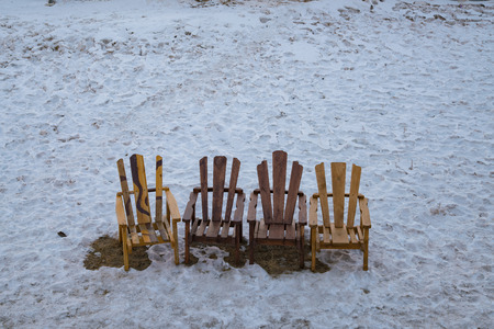 Wooden chair over snow ground in winter season backgroundの写真素材