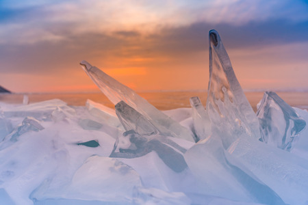 Sunset sky over Ice cracked in Baikal water lake, natural landscape backgroundの写真素材