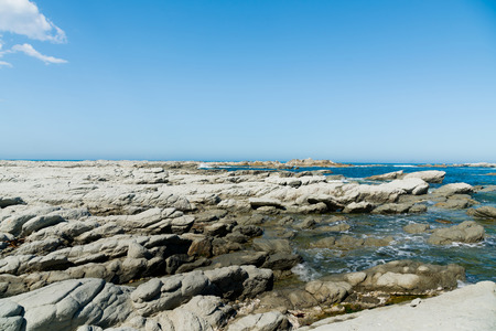 Natural stone beach over blue seacoast skyline, natural landscape backgroundの写真素材